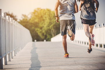 young couple runner running on running road in city park